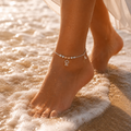 Close-up of rose-gold fan CZ charms and a CZ pendant on the Silvme 925 sterling silver rose-gold CZ bell charm anklet