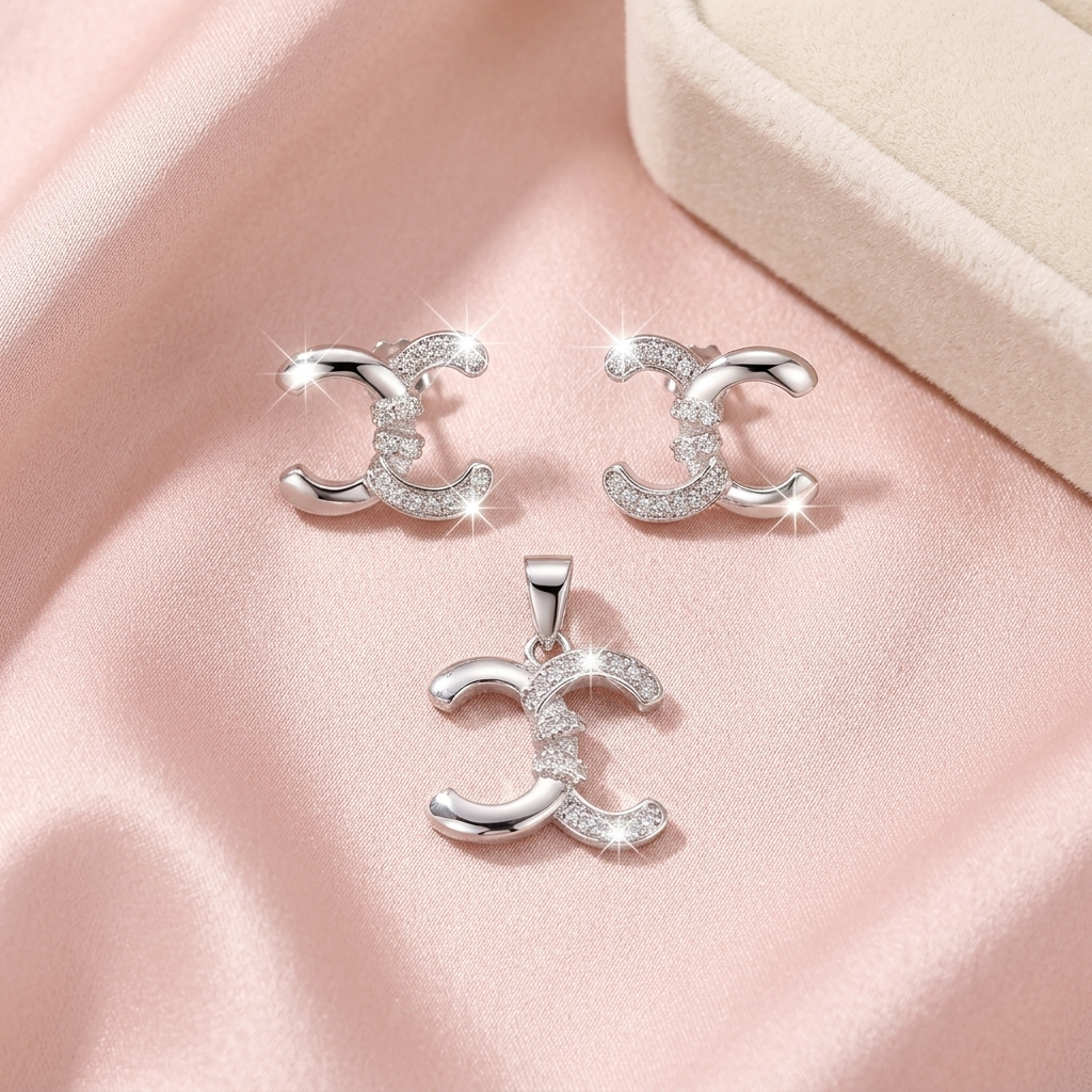 Interlocking crescent pendant and matching studs styled on soft pink satin