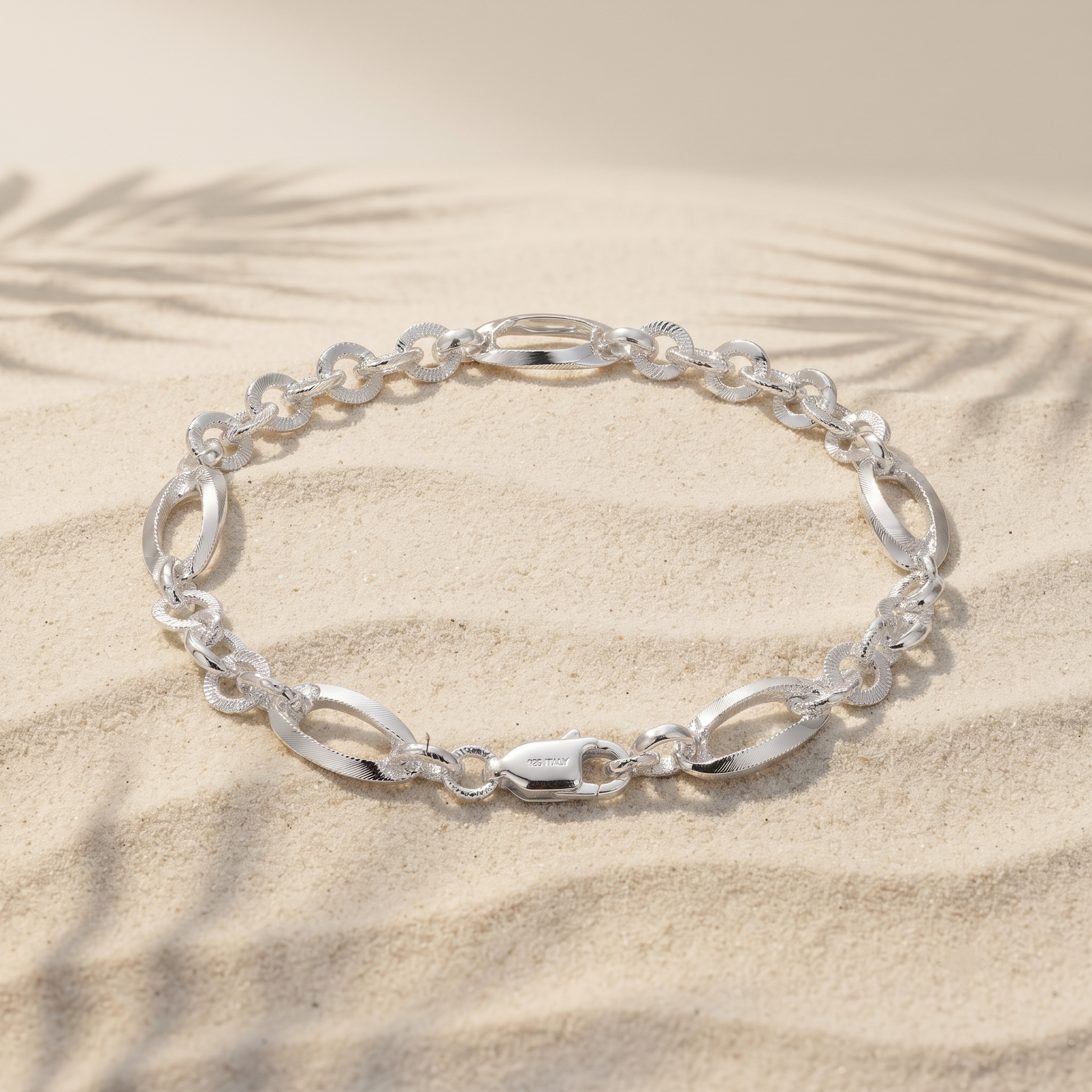 Full length of the oval station rolo bracelet showing its polished silver-tone finish