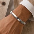 Close-up of broad polished plates set between finely textured connector links on the Silvme wide panel link bracelet