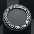 Full length of the engraved panel link bracelet showing its polished silver-tone finish