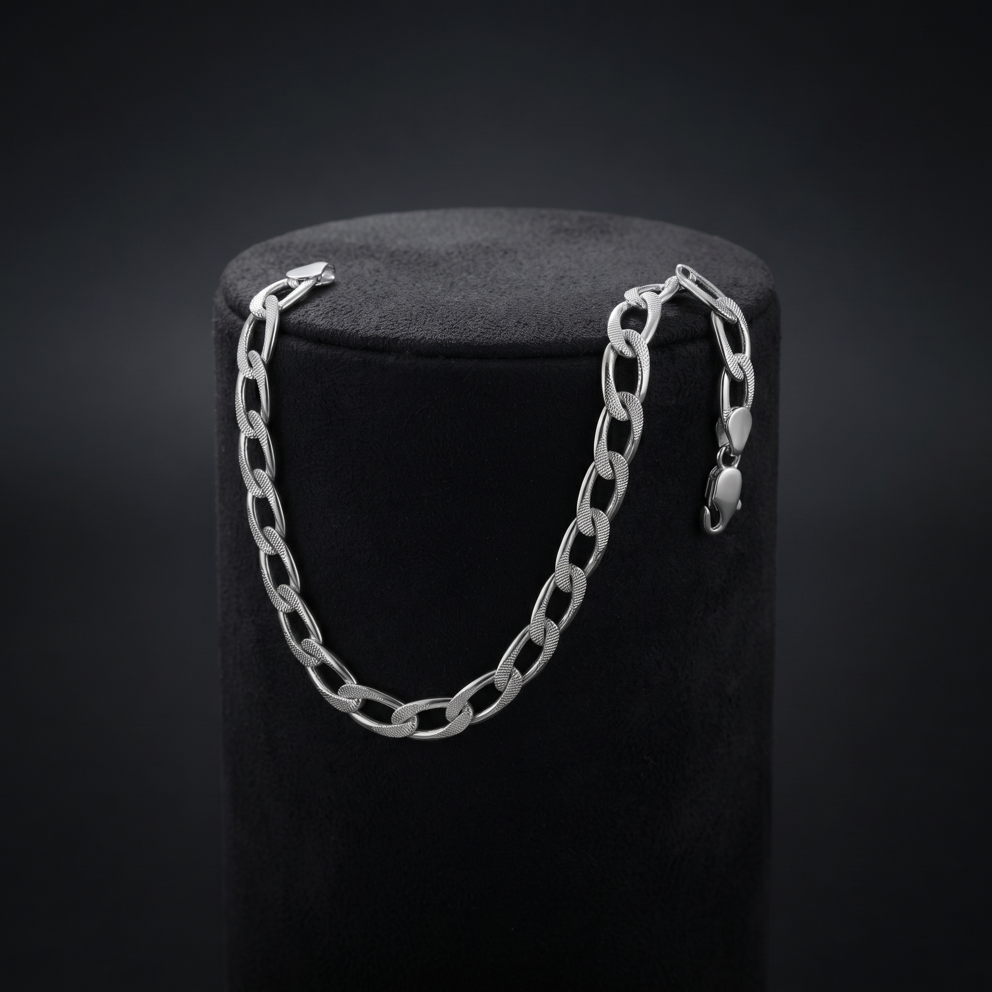 Full length of the curb chain bracelet showing its polished silver-tone finish