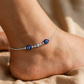 Close-up of twin blue evil-eye beads with silver beads on the Silvme 925 sterling silver twin blue evil eye anklet