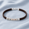 Close-up of a brown braided cord anchored by a pierced silver-tone centre bar on the Silvme braided cord bracelet with silver