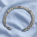 Full length of the wide panel link bracelet showing its polished silver-tone finish