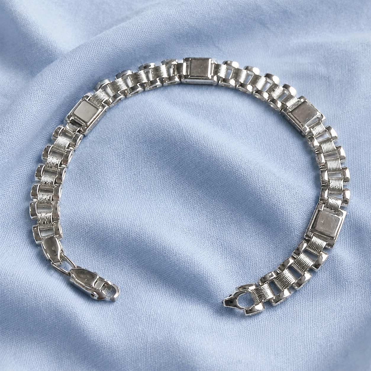 Full length of the wide panel link bracelet showing its polished silver-tone finish