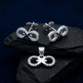 Ribbon Bow 925 sterling silver pendant and stud earrings jewellery set with cubic zirconia by Silvme â€” angled studio view
