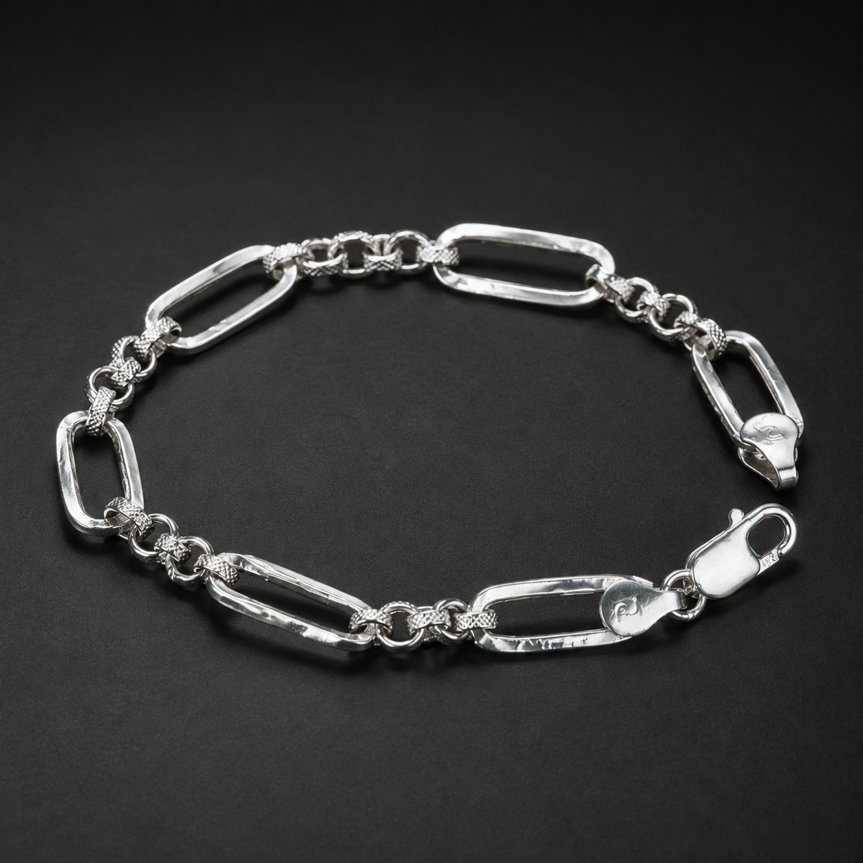 Close-up of long paperclip links separated by small round connectors on the Silvme paperclip and round link bracelet