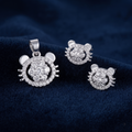 Cat face pendant and matching studs arranged on deep navy velvet
