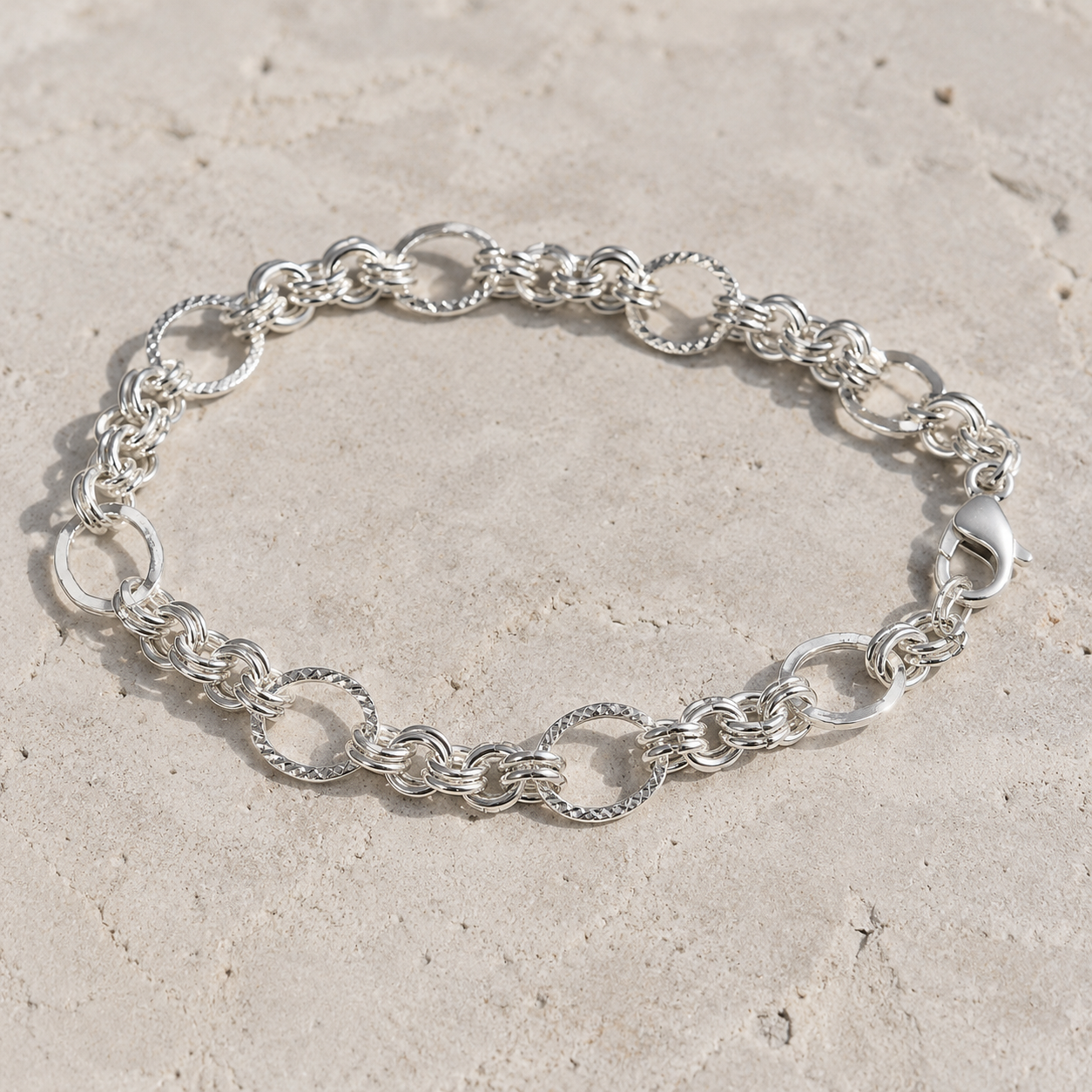 Full length of the textured rolo chain bracelet showing its polished silver-tone finish