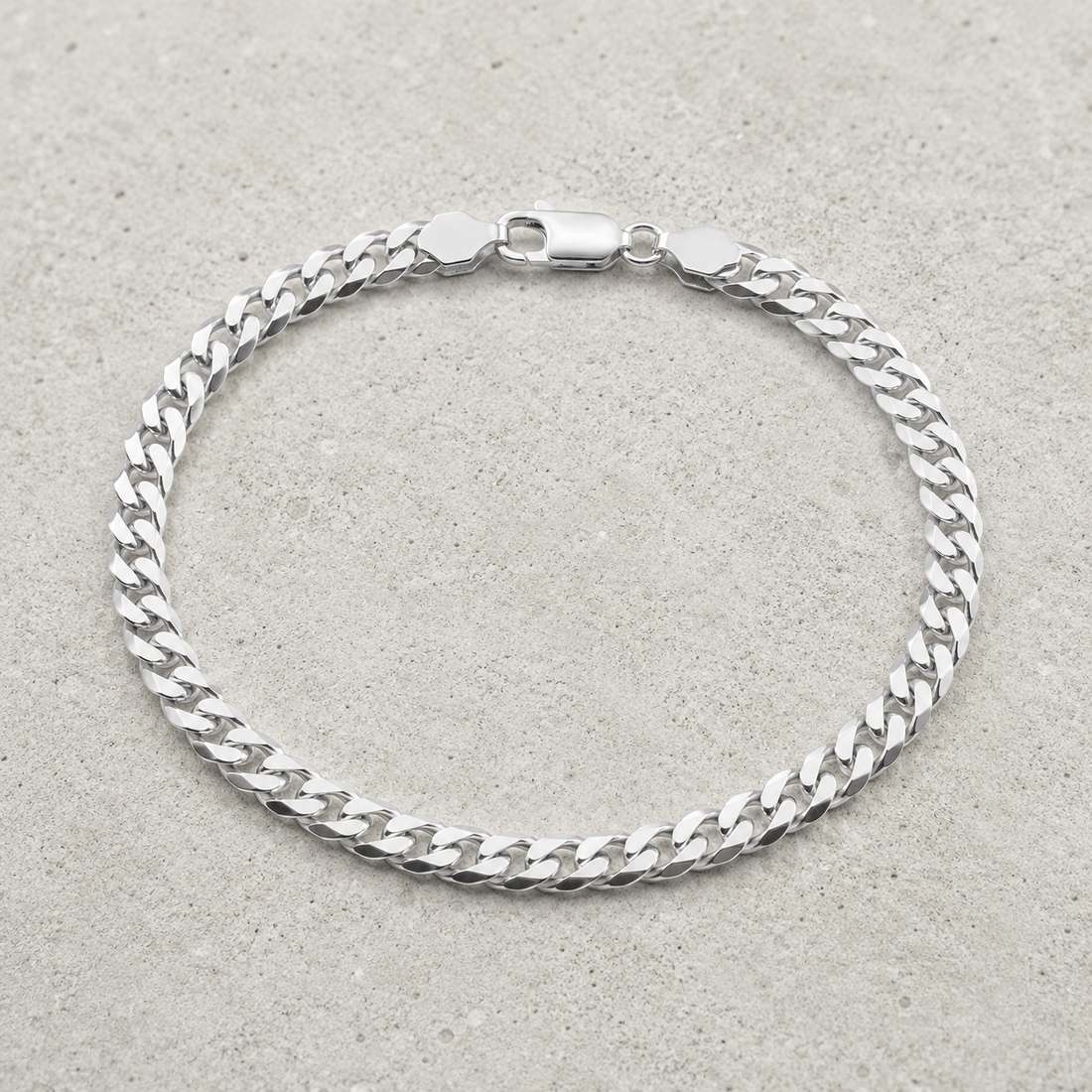 Full length of the heavy curb chain bracelet showing its polished silver-tone finish