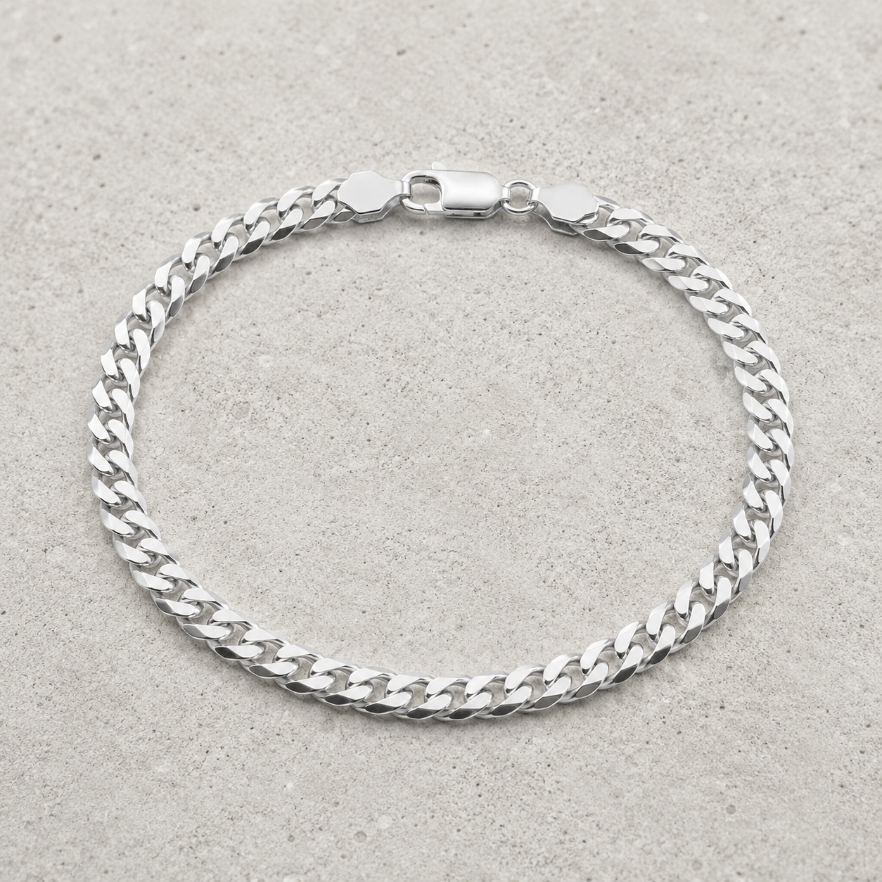 Full length of the heavy curb chain bracelet showing its polished silver-tone finish