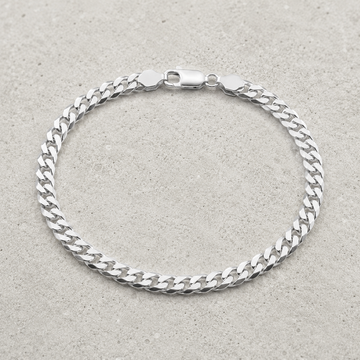 Full length of the heavy curb chain bracelet showing its polished silver-tone finish
