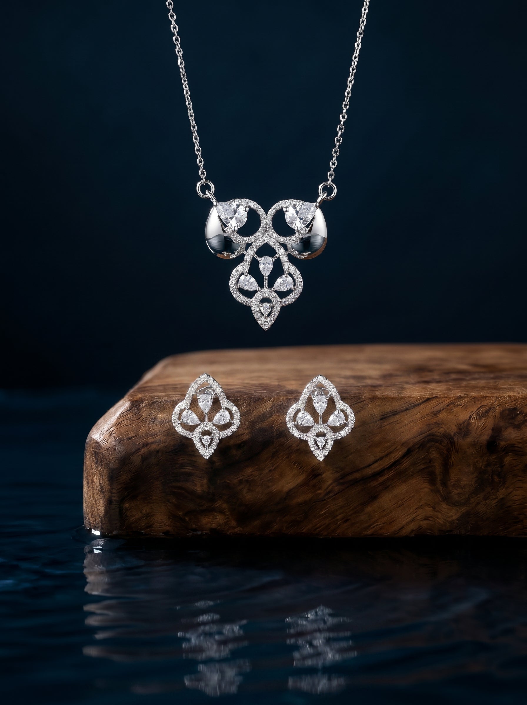 Ornate Petal 925 sterling silver pendant necklace and stud earrings jewellery set with cubic zirconia by Silvme â€” overhead flat-lay view