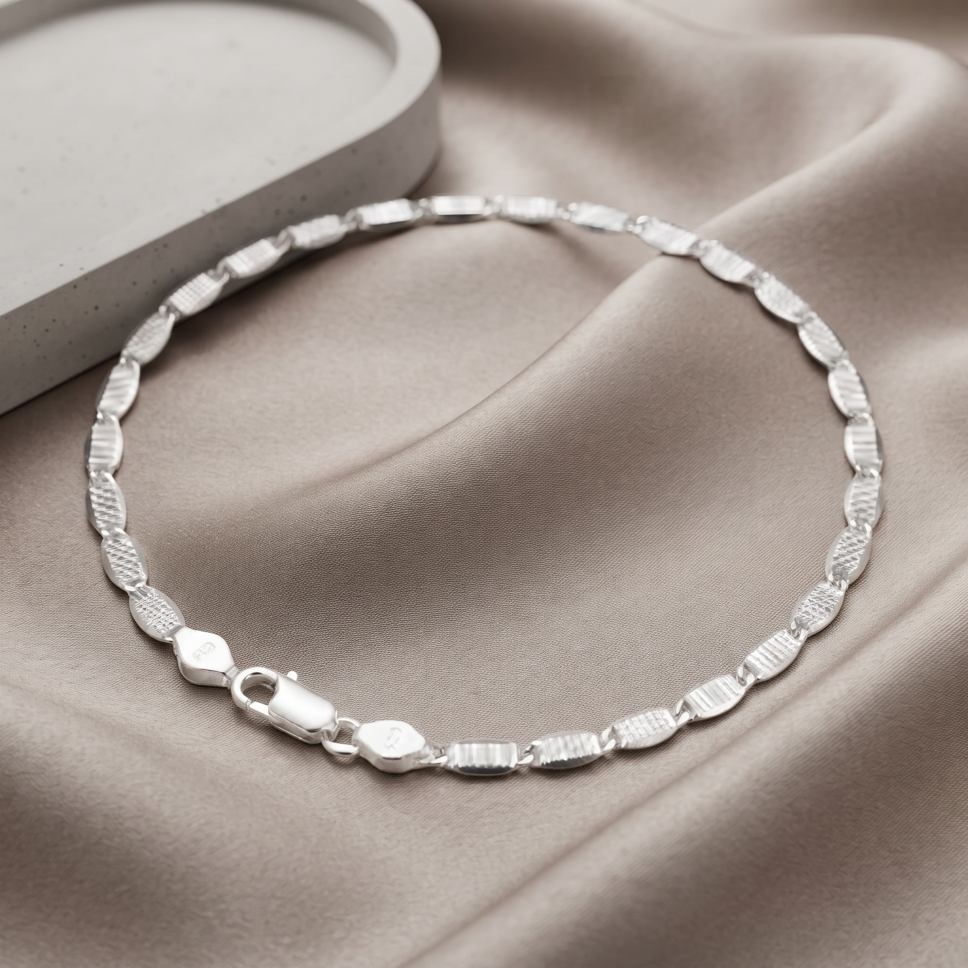 Full length of the flat mariner link bracelet showing its textured silver-tone finish