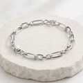 Close-up of elongated flat links paired with rounder ovals for an easy, open look on the Silvme elongated figaro bracelet