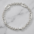 Close-up of a rolo chain punctuated by open oval stations with a hammered edge on the Silvme oval station rolo bracelet