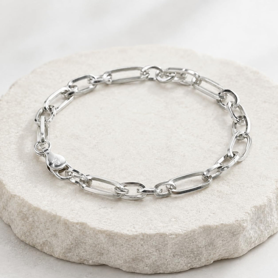 Close-up of elongated flat links paired with rounder ovals for an easy, open look on the Silvme elongated figaro bracelet