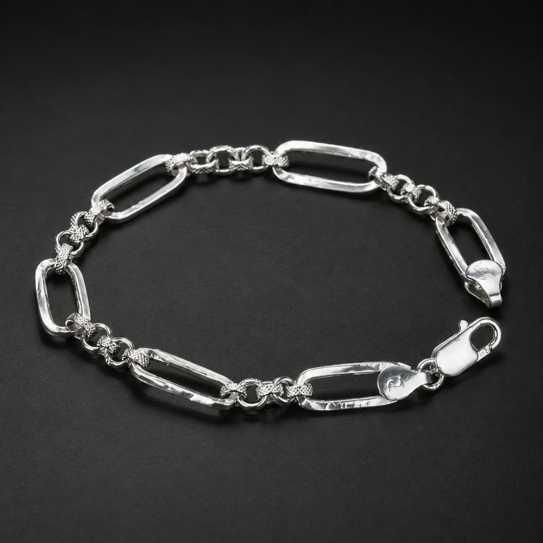 Close-up of long paperclip links separated by small round connectors on the Silvme paperclip and round link bracelet