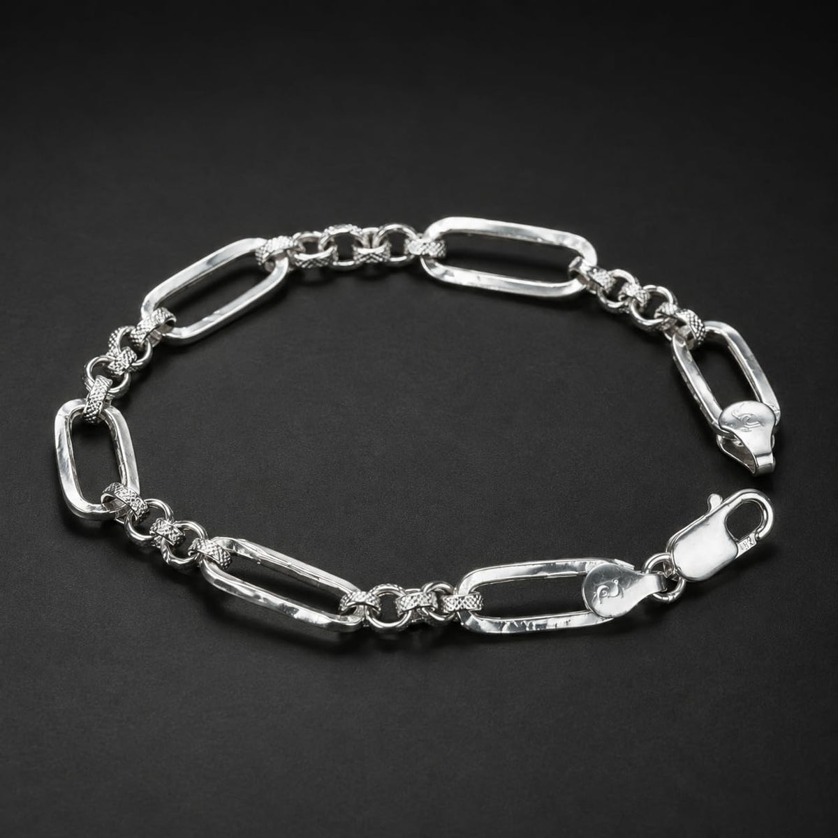 Close-up of long paperclip links separated by small round connectors on the Silvme paperclip and round link bracelet