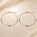 Close-up of polished silver beads and a small fan charm on the Silvme 925 sterling silver silver bead snake chain anklet