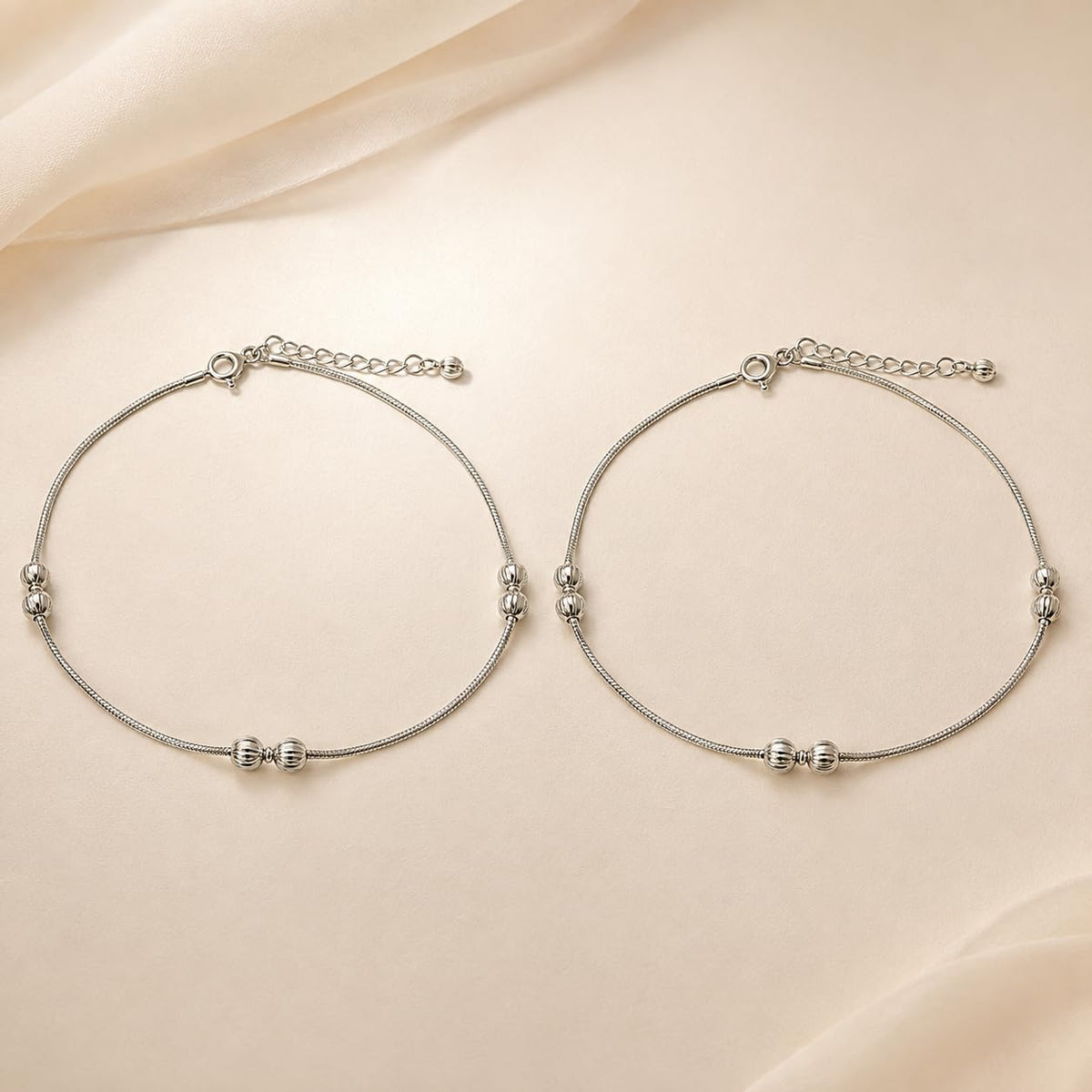 Close-up of polished silver beads and a small fan charm on the Silvme 925 sterling silver silver bead snake chain anklet