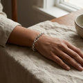 Full length of the oval station rolo bracelet showing its polished silver-tone finish