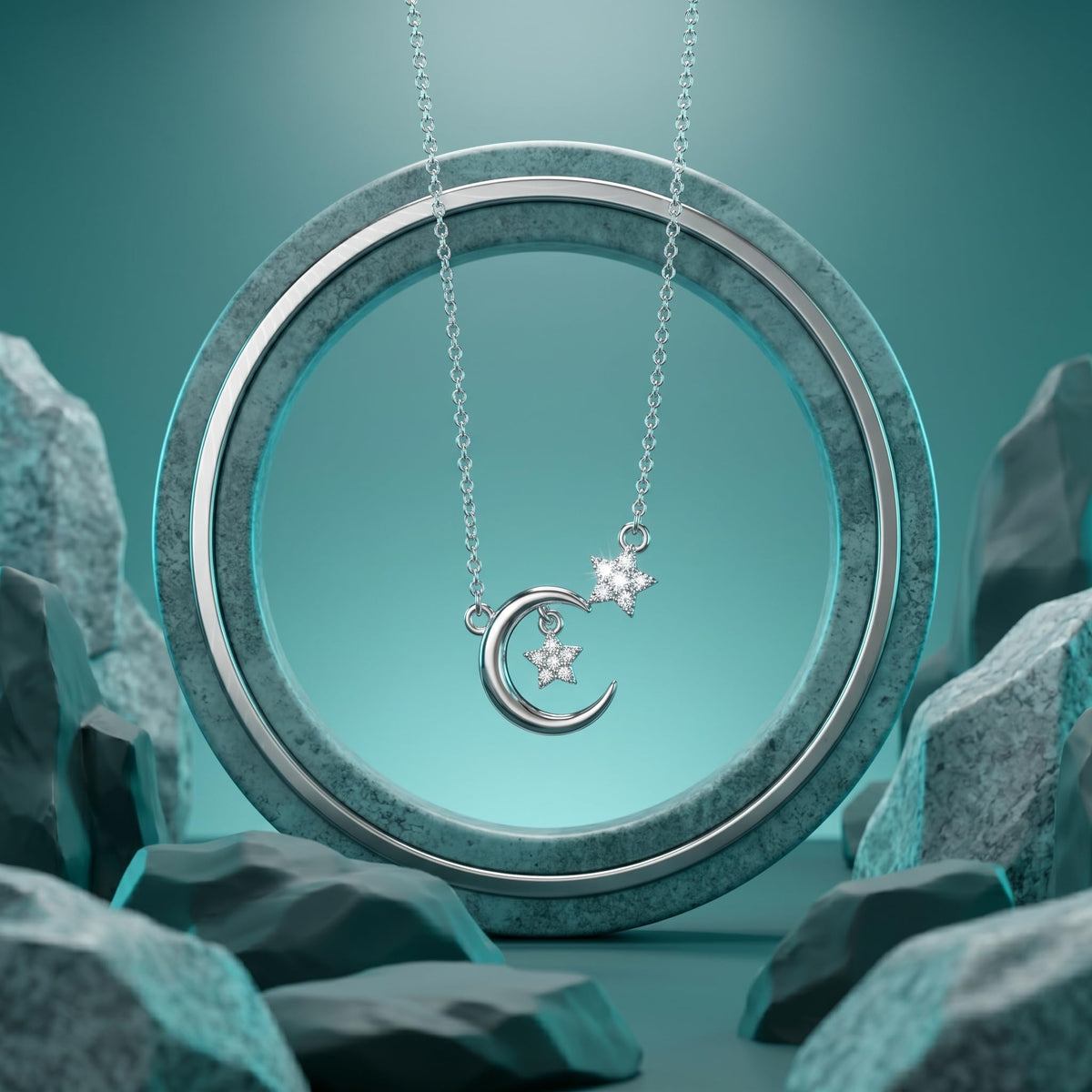 A silver necklace with a crescent moon and star pendant, displayed on a textured teal ring with surrounding rocks against a teal background.