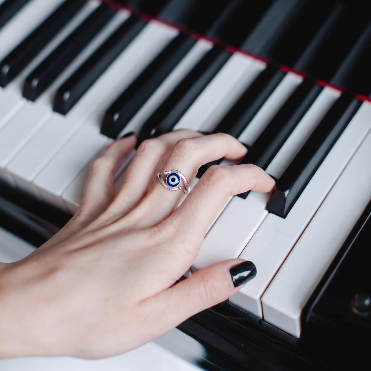 Close-up of the navy evil eye on a curved bypass band, Silvme 925 sterling silver evil eye bypass ring for women