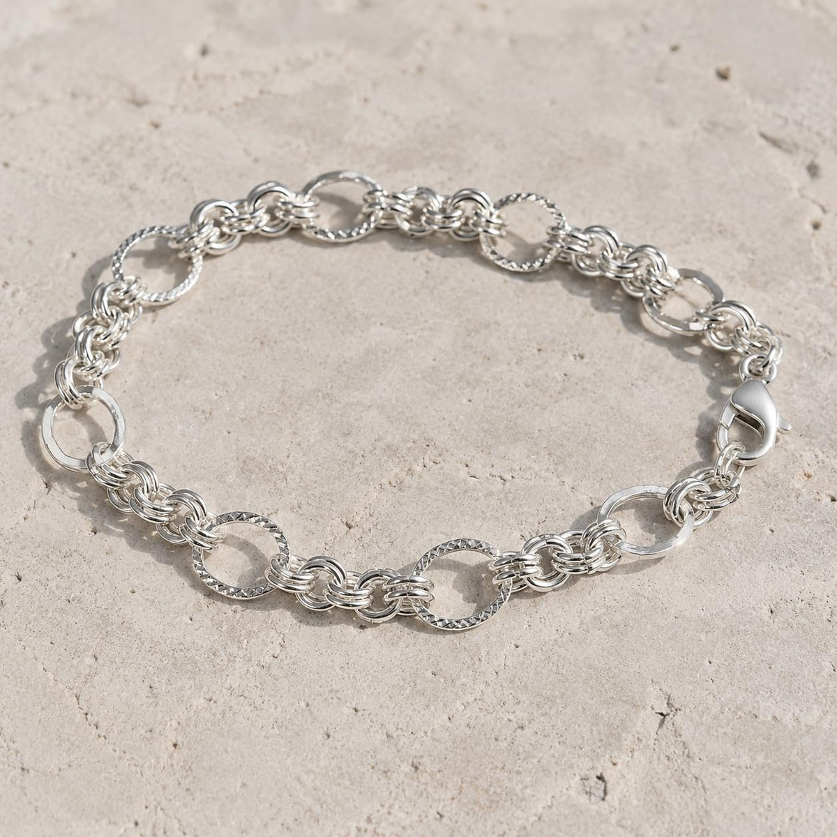 Full length of the textured rolo chain bracelet showing its polished silver-tone finish