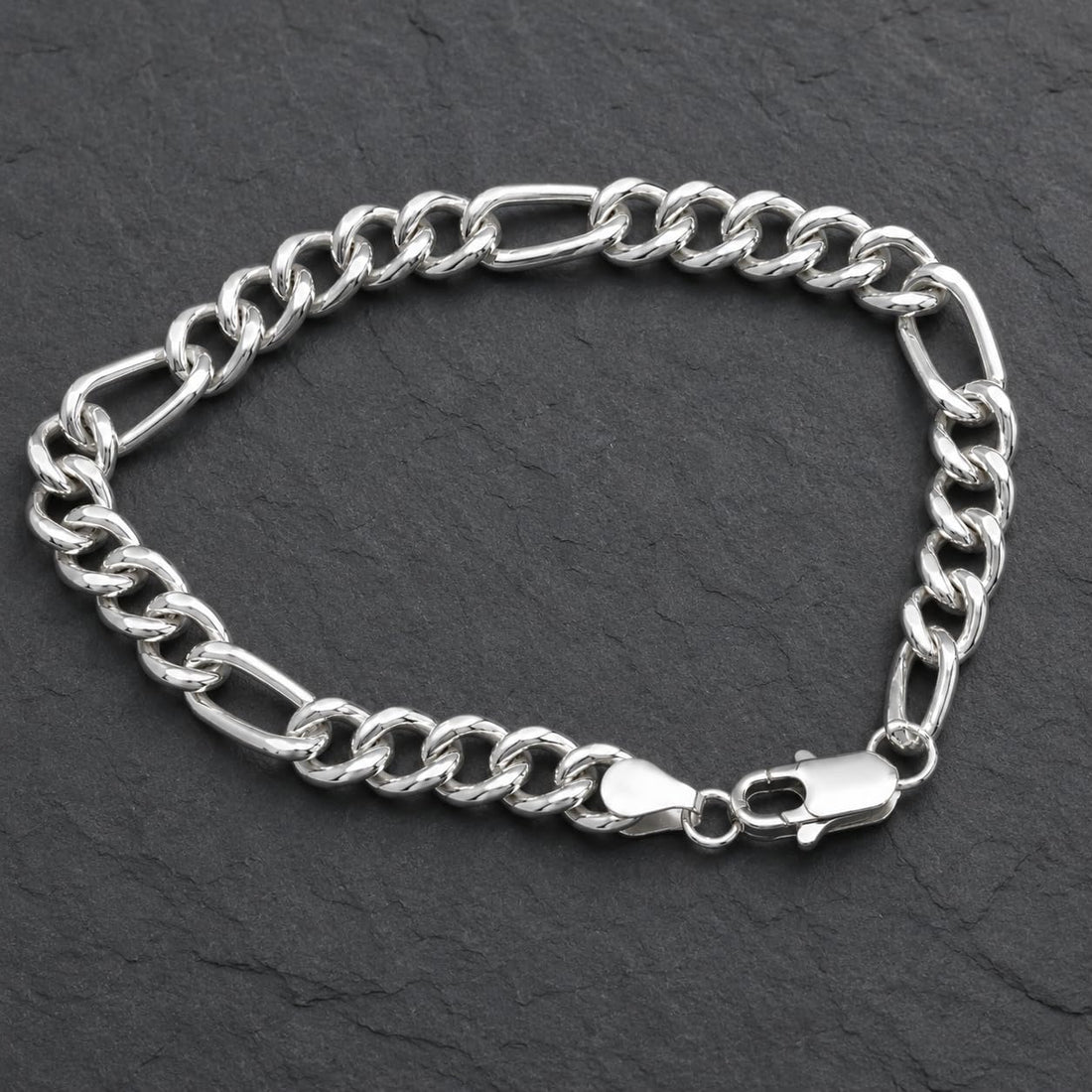 Close-up of flat Figaro links with a broad, mirror-bright face on the Silvme polished figaro chain bracelet